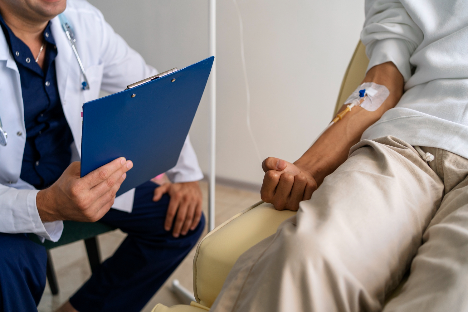 Male patient hooked in an IV drip with a doctor beside him.