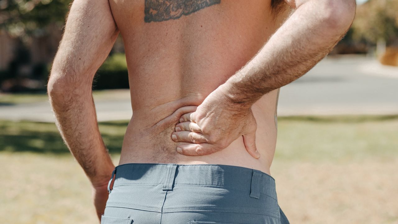 A man holding his back due to back pain