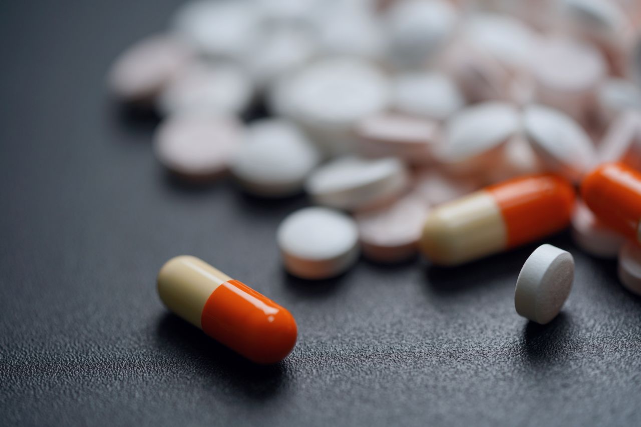 Assorted pills and capsules on a dark background