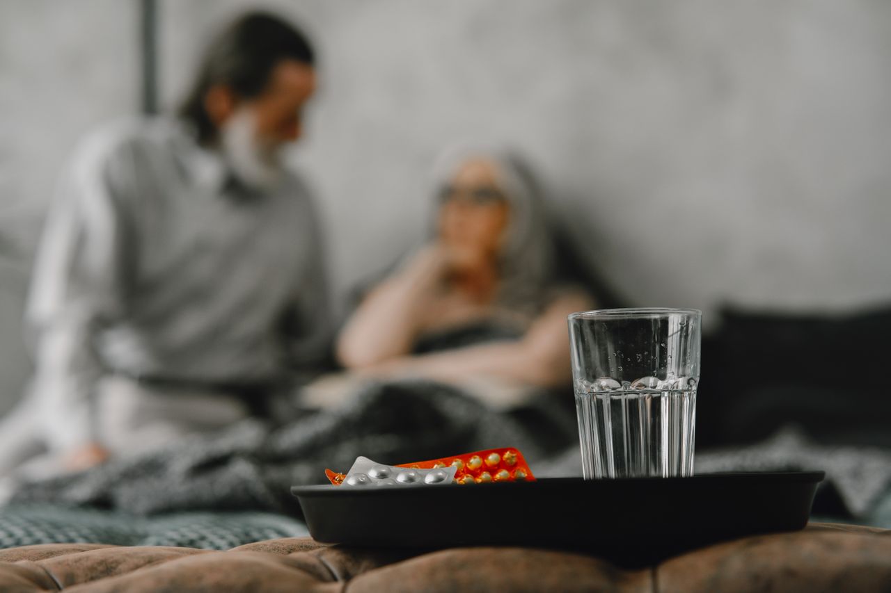Elderly couple focuses on health support in a home setting with medications.