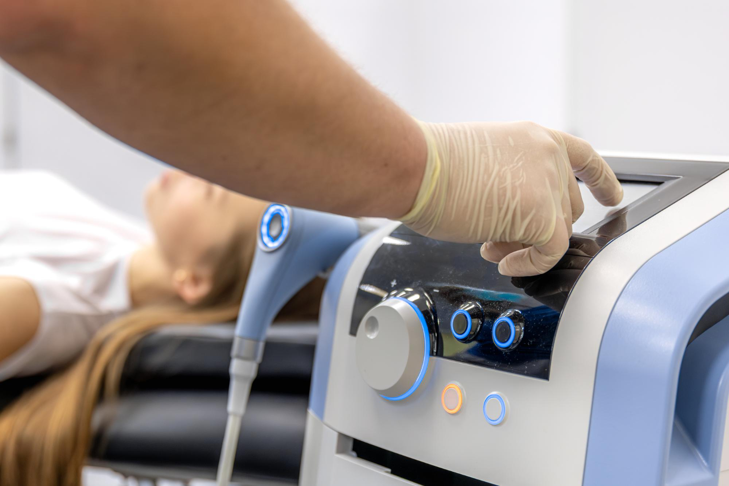 Physiotherapist performs ultrasound therapy on female patient.
